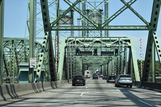 The Washington state border lines the Columbia River midway between Hayden Island and the Vancouver river side. The vertical-lift section of the Interstate Bridge is toward the north end of the span.