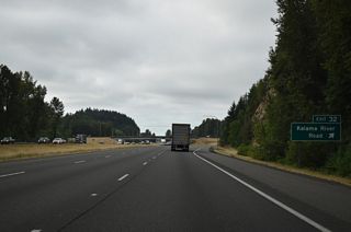 Drays Mound rises alongside I-5 south where Exit 32 departs. Kalama River Road meets Old Pacific Highway north and Meeker Drive south, both of which are old alignments of U.S. 99/830. Kalama River Road continues from Spencer Creek Business Park to Pigeon Springs.