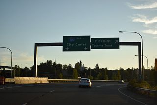 The exit to E 26th Street follows from I-705 to the historic alignments of U.S. 99 on Pacific Avenue at Tacoma Way and east to Puyallup Avenue. Interstate 705 lines a viaduct north to the SPUI with SR 509 and S 21st Street.