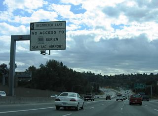 Lowering to cross the BNSF Railroad and Duwamish River on I-5 south. The HOV-2 lane partitions onto a separate roadway to Exit 154 for Interstate 405 north and SR 518 to SEA Airport.