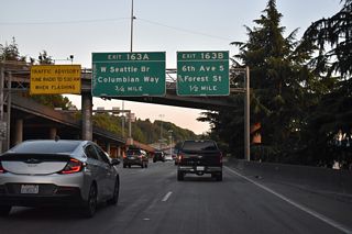 Interstate 5 south travels below I-5 north along the hill side west of Beacon Hill. Passing under Beacon Avenue, the freeway advances to Exit 163 B for Forest Street west.