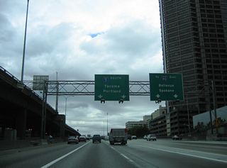 Traffic partitions at Exit 164 for the c/d roadway to Interstate 90 east and the ramps for Dearborn Street, 4th Avenue S, and Airport Way. I-90 represents the longest Interstate highway in the system at 3,020.54 miles, concluding to the east of I-93 in Boston, Massachusetts.
