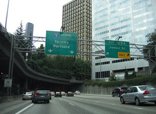 Exit 165 A departs between the two tunnels with two lanes for James Street and Seattle City Hall. This ramp remains underground until after Spring Street.
