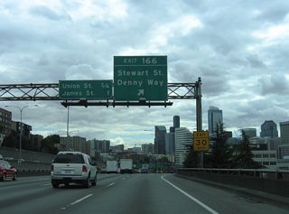 Stewart Street angles southwest from Exit 166 to Denny Way and Pike Place in Downtown Seattle. Denny Way heads west to Belltown and east to Capitol Hill from Interstate 5.