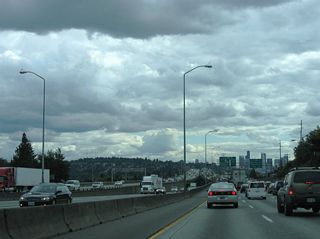 Interstate 5 crosses Lake Washington Ship Canal, a waterway linking Lake Union and Portage Bay. The Express Lanes descend onto a deck below the eight lane mainline.