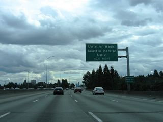 Interstate 5 rises onto a viaduct between Weedin Place and Ravenna Boulevard near the Meridian neighborhood. Interests to Woodland Park Zoo and Seattle Pacific University are directed onto NE 50th Street west toward Fremont. NE 45th Street follows as the route to the University of Washington campus on Union Bay.