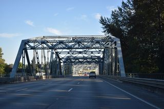 Opened in 1933 for U.S. 99, a steel through truss bridge takes Interstate 5 south across the Stillaguamish River.