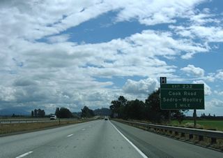 Interstate 5 lowers to Butler Flat ahead of Exit 232 with Cook Road.