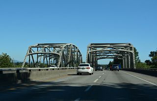 The southbound span across the Nooksack River opened in 1971 as part of Interstate 5. The northbound bridge opened in 1955 as a part of U.S. 99 (Pacific Highway).