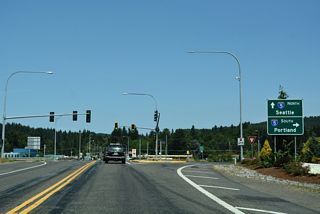 Business Loop I-5/SR 411 (Huntington Avenue) angle northeast across the BNSF Railroad ahead of the diamond interchange (Exit 49) with Interstate 5.