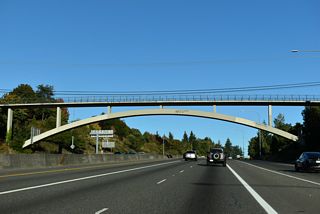Continuing east, SR 16 passes under an arched pedestrian bridge connecting segments of Skyline Drive nearby.