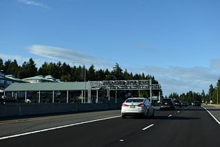 The toll plaza for the Tacoma Narrows Bridge eastbound is north of the 24th Street NW overpass.
