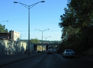 Maple Street drops below grade and passes under Broadway Avenue along a short expressway segment leading south across the Spokane River into Peaceful Valley.