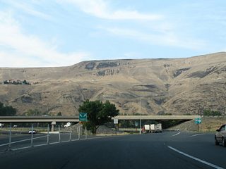 SR 823 follows a two lane roadway between the east and westbound roadways of I-82/U.S. 97 across the Naches and Yakima Rivers to Selah Road. Drivers may use either the state route or the freeway north to Exit 26 for Selah.