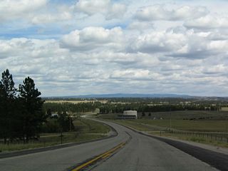 Reaching a rise in the roadway, the trees part for a series of valleys.