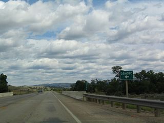 Oshoto is not located on eastbound U.S. 14; it is located to the northwest of Carlile via local roads (Cabin Creek Road west to Oshoto Road). East of here, U.S. 14 is also known as the continuation of Cabin Creek Road.
