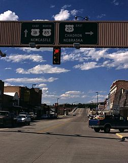 U.S. 20 splits off from U.S. 18-85 and heads east into Nebraska via Third Street; U.S. 18-85 north continue along Cedar Street over the railroad viaduct toward Edgemont, South Dakota, and Newcastle. Note the change in the shapes of the U.S. route shields. Photo taken by Jonathan Winkler, 8/00 and Dale Sanderson, 04/04.