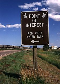 Following eastbound U.S. 18 and U.S. 20, the marker for Red Wood Watertank is located near Lusk. According to the Niobrara County Library, "The redwood water tank was built to furnish water for the steam engines of the Fremont Elkhorn and Missouri Valley Railroad. It came to Lusk July 13, 1886. It was a part of the North Western Line and later became the Chicago North Western Railroad. Water was furnished from a well by a windmill. The original site was several hundred feet west of the present location. Water came from a hand dug well and steam power. Later another well was drilled and the old one was abandoned. The tank is one of six left standing in the United States." (Citation is from "Niobrara Historical Brevity" published by the Niobrara Historical Society, in observance of the Lusk Centennial 1886-1986.)
