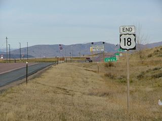 Westbound U.S. 18 ends signage along Westbound U.S. 18-20 approaching Interstate 25 and U.S. 26-87 at Orin Junction. The freeway is just ahead, beyond the rise in the road.