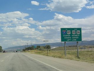 Continuing east, U.S. 20-26 passes by Hells Half Acre, Powder River, and Natrona before entering the Casper metropolitan area. Consisting of Mills, Bar Nunn, Casper, and Evansville, this is the most populated urban area in Wyoming with over 50,000 residents between the four communities. U.S. 20-26 expands to four lanes as it passes by Natrona International Airport, and the highway splits at the next major intersection. U.S. 20-26 bypasses the city to the north, so it splits off the route and joins Interstate 25 and U.S. 87. Business U.S. 20-26 continues east via the Yellowstone Highway into Mills and ultimately Casper. After passing through downtown Casper, the business route reconnects with Interstate 25.