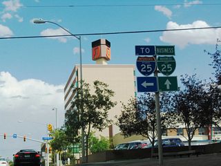 Now approaching Center Street, this sign assembly shows that Business Loop I-25 joins together with U.S. 20-26 Business. To Interstate 25, follow Center Street north; the business loop (and U.S. 87 Business) merges onto eastbound U.S. 20-26 Business.