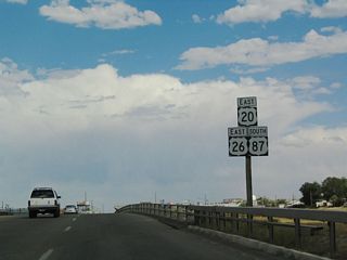 Upon crossing over Interstate 25, U.S. 20-26-87 are signed together as an independent route. The highway expands into a four-lane expressway, and it is possible that this route was considered as a possible route for Interstate 25 before the construction of Interstate 25 on its current alignment.