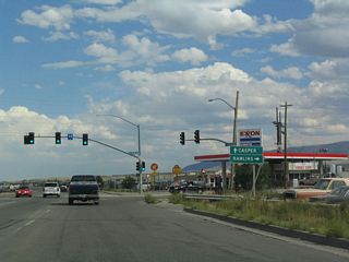 A simplified sign shows that U.S. 20-26 Business continues east to Casper, while Wyoming 258/Wyoming Boulevard travels south to Wyoming 220 en route to Rawlins. A left turn at this intersection connects to Hudson Street.