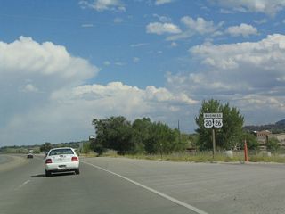 Another reassurance shield assembly is posted on eastbound after the Wyoming 254 junction. Between Wyoming 254 and just east of Wyoming 220, U.S. 20-26 Business follows the north bank of the North Platte River. The river is blocked off with a chain link fence, and no parking is allowed on the side of the road to see the river, even though it is very close to the highway. For a better view of the river, visit the Platte River Parkway, Crossroads Park, or North Casper Park. To Crossroads Park, turn north on Wyoming 220 (Poplar Street) and pass under Interstate 25. For North Casper Park, continue east on U.S. 20-26 Business to Business Loop I-25/U.S. 87 Business/Wyoming 255 (Center Street) north. After passing under Interstate 25, turn east on K Street to North Casper Park.