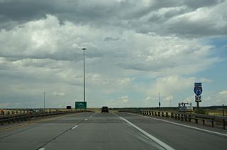 Confirming markers for I-25/U.S. 87 stand along the viaduct spanning the Union Pacific Railroad yard and adjacent U.S. 30 (Lincolnway).