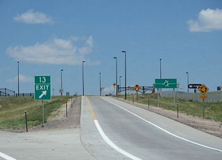 Construction in 2010 converted the exchange at Exit 13 into a dumbbell interchange with six-leg roundabouts added that also connect with parallel Bishop and Hynds Boulevards. 