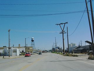 Home to 5,776 people (per the 2000 Census), Torrington has hovered around this number of residents since at least 1990. Booms and busts in agriculture greatly impact the economy and population of this small city. U.S. 26-85 enter the industrial part of town, passing by several supply yards on its way into town. The Torrington water tower dominates the skyline along with storage tanks.