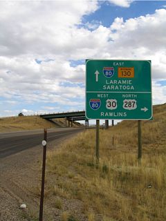 U.S. 30 west / U.S. 287 meet I-80 and Wyoming 130-230 at Walcott Junction. Follow Interstate 80 east to Elk Mountain, Arlington, and Laramie; follow Interstate 80 west to continue along U.S. 30-287 west to Rawlins. Straight ahead, Wyoming 130 and Wyoming 230 proceed south toward Saratoga. South of Saratoga, Wyoming 130 curves east to Laramie, and Wyoming 230 proceeds south to Encampment and crosses into Colorado where it becomes Colorado 125 en route to Three Way.