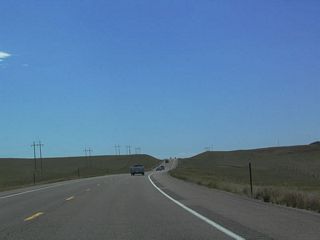 Standard H-frame power poles line U.S. 85 to the east as the highway continues south toward Lusk.