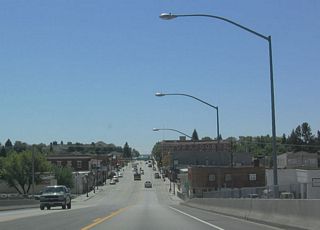 Downtown Lusk spreads out on southbound U.S. 18-85 as the highway descends from the railroad viaduct. A city at 5,015 feet, U.S. 85 will lose elevation upon reaching the North Platte River Valley (Lingle and Torrington), and then it will gain elevation to reach Cheyenne at elevation 6,062 feet.