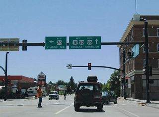 Southbound U.S. 18-85 reaches its junction with U.S. 20, which follows Third Street east toward Van Tassell and Chadron, Nebraska. The three U.S. routes follow Cedar Street south through the remainder of downtown Lusk.