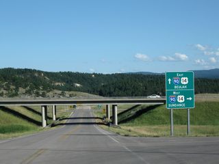 Southbound Wyoming 111 meets the onramp to Interstate 90 and U.S. 14 west to Sundance and Gillette. Continue under the bridge to connect to Interstate 90 and U.S. 14 east to Spearfish, Sturgis, and Rapid City.
