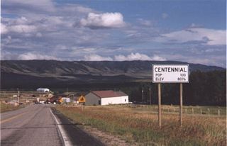 Westbound Wyoming 130/Snowy Range Road enters the unincorporated community of Centennial, which was established in 1876, the year of the centennial of the United States of America. Centennial, with a population of 270 as of the 2010 Census, sits at an elevation of 8,074 feet above sea level and is the gateway community leading into the Snowy Range. Known formally as the Medicine Bow Mountains, the Snowy Range loom large behind the small community. During winter, skiers travel through Laramie and Centennial en route to the Snowy Range Ski Area. This style of population sign (black lettering on white sign) is no longer in use in Wyoming; they are now white lettering on green sign.
