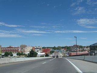 Downtown Cheyenne spreads out as Interstate 180 descends from the viaduct onto Warren Avenue northbound. The state capitol is readily identifiable by its golden dome.