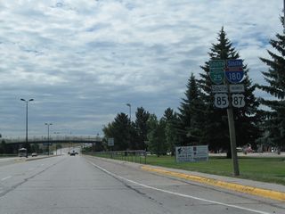 The Interstate 180 reassurance shield assembly is located after the Ninth Street intersection. It was state-named in 2002, but it was replaced with a neutered shield by 2004. This shield reversed a trend of adding more state-name Interstate shields in Wyoming after the 2001 experiment to add more neutered shields to the state's Interstate system. By 2012, the state name had been restored to this assembly (not shown here).
