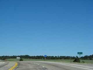 This mileage sign along U.S. 287 north provides the distance to Laramie (25 miles) and Rawlins (124 miles). Omitted is the distance to tiny Tie Siding, which is located at the point where the Union Pacific Railroad descends west from the Laramie Mountains and curves north to follow U.S. 287 north into Laramie.