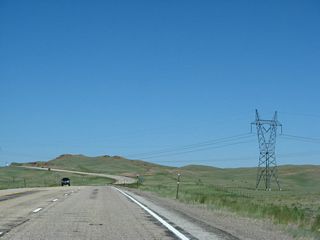 U.S. 287 passes under the two sets of power lines and continues to ascend to the summit of Pumpkin Vine Hill, elevation 8,106 feet above sea level. After reaching this height, U.S. 287 will descend into the Laramie Basin and widen to a four-lane expressway configuration.