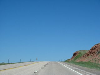 At the top of the grade, U.S. 287 reaches Pumpkin Vine Hill. Albany County Route 241, an unpaved road, departs U.S. 287 and follows Pumpkin Vine Hill Road east to connect with Albany County Route 234 and Laramie County Route 206 en route to Interstate 80 and U.S. 30 Exit 339 in the Laramie Mountains. This route is not advisable without local guidance. Ahead, U.S. 287 will begin a long descent into the Laramie Basin.
