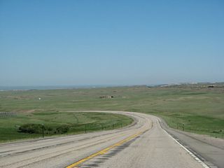 Descending from the summit of Pumpkin Vine Hill, U.S. 287 widens to a four lane expressway configuration. When we passed through here in 2008, the widening had not yet reached this far south, so our pictures show the old, two lane configuration. However, by 2013, the highway had been widened to a four-lane expressway complete with center median barrier north of Pumpkin Vine Hill. According to the U.S. 287 Laramie, Wyoming, to Colorado State Line (FHWA-WY-FONSI-07-01) Finding of No Significant Impact (2007), "The existing lanes would serve as the two southbound lanes for the improved roadway while the two northbound lanes would be built east and 76 feet from the existing lanes." To the west, the Medicine Bow Mountains (better known as the Snowy Range) come into view along U.S. 287 for the first time.