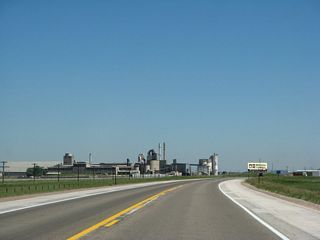 Once past the concrete plant, U.S. 287 approaches the State of Wyoming Port of Entry (weigh station) for commercial vehicles. At the end of this series, U.S. 287 enters the city of Laramie ("The Gem City of the Plains"). Laramie had a population of 30,816 as of the 2010 Census and 27,204 as of the 2000 Census. Laramie sits at an elevation at 7,165 feet above sea level; the War Memorial Stadium elevation is listed at 7,220 feet above sea level.