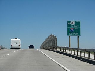 U.S. 287 will proceed north along Third Street into downtown Laramie, while Interstate 80 serves as a bypass route around Laramie. Its business route follows a combination of Curtis Street, Third Street, and Grand Avenue through town. This sign was modified to eliminate the state name from the Interstate 80 route marker and also to change "1200 feet" to "second right."
