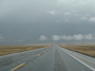 Just outside of Tie Siding, formerly two-lane U.S. 287 (which has since been expanded to a four-lane expressway configuration through here) is wet from a recent storm.