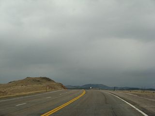 Now at the top of Pumpkin Vine Hill, U.S. 287 will proceed south toward the Wyoming-Colorado State Line. The northbound side of the highway has two lanes, while southbound has one lane. This is actively changing as construction continues to extend the four-lane expressway south toward the state line in 2014. A set of power lines cross over U.S. 287.