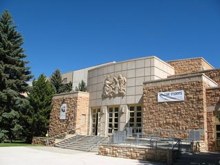 The College of Education, with its "Go forth and teach this people" inscription is just north of the walkway. The sandstone bricks found on many of the central buildings on the campus was quarried in southeastern Wyoming and is a design theme for many buildings, going back to the original design of the university's Old Main.