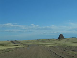 Southeast of the Vedauwoo Road interchange, follow the gravel road toward Ames Monument. Near Ames Monument, the gravel road connects to the 1913 Lincoln Highway near the site of the town of Sherman (now gone). The Ames Monument is a hollow, pink granite pyramid that marks the former highest point on the 1880s alignment of the Union Pacific Railroad (8,247 feet above sea level). It was designed by Henry Hobson Richardson, a noted architect of that era. Today, the railroad follows a different alignment over Sherman Hill that affords a gentler slope a bit to the south. The railroad and Interstate 80 separate at the Buford interchange (Exit 335) and do not reunite until the Union Pacific Railroad Viaduct (U.S. 287) in Laramie. To follow the old Lincoln Highway to Tie Siding, continue southwest past Ames Monument. Consult a detailed map of the area to determine the old Lincoln Highway between Buford and Tie Siding.