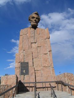The bronze bust of Abraham Lincoln was first installed at the highest point on the Lincoln Highway in 1959, which is located on the service road between Exits 323 and 329. The service road on the south side of the freeway follows the original route of U.S. 30/Lincoln Highway, and the bust was placed at the summit of the service road at an elevation of 8,835 feet. The old highway became the service road when the freeway was opened in 1969. At the same time, the bust of President Lincoln was moved to its present location, at the Summit Rest Area at an elevation of 8,640 feet.